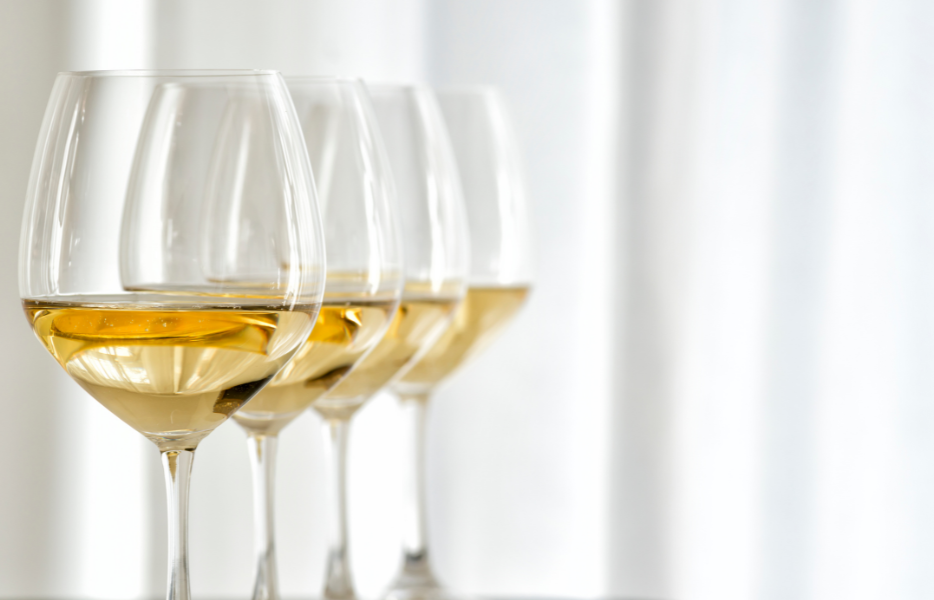 4 glasses of white wine on a white background