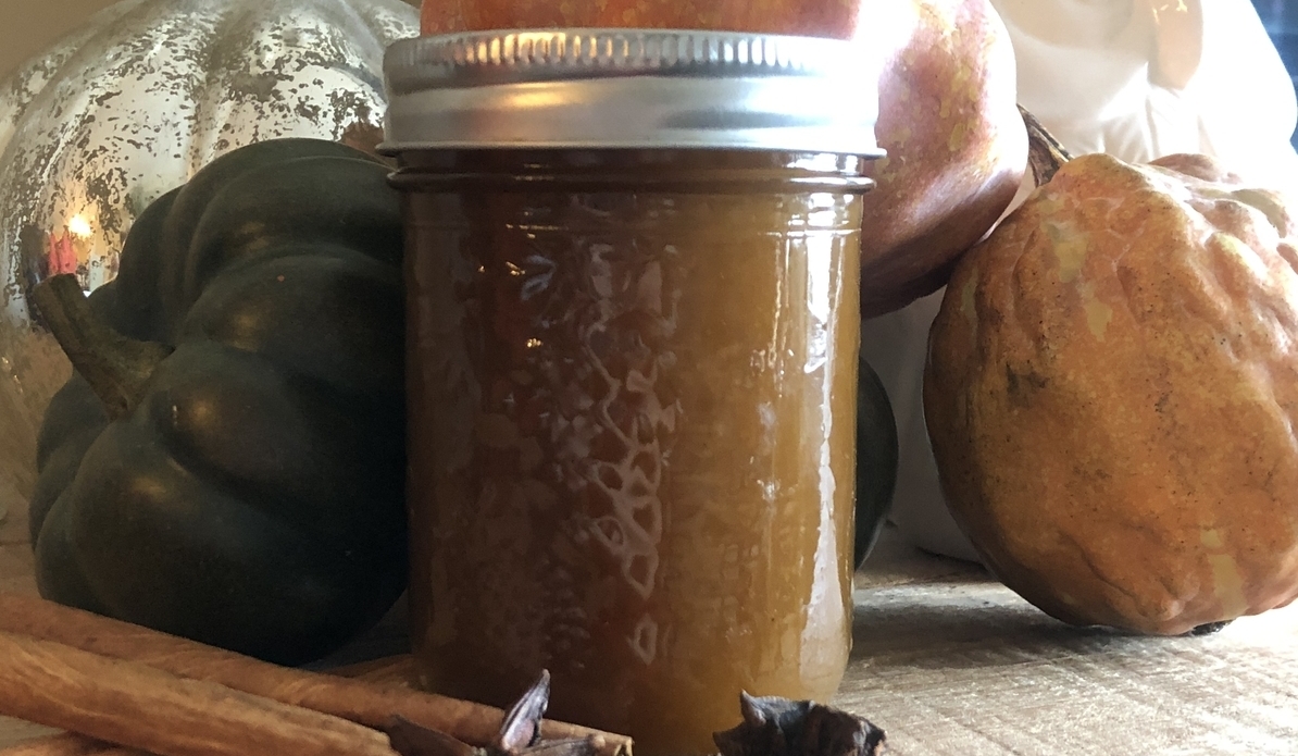 pumpkin spice syrup in a jar surrounded by pumpkins and spice
