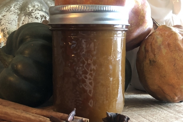 jar of pumpkin spice syrup surrounded by pumpkins and spices