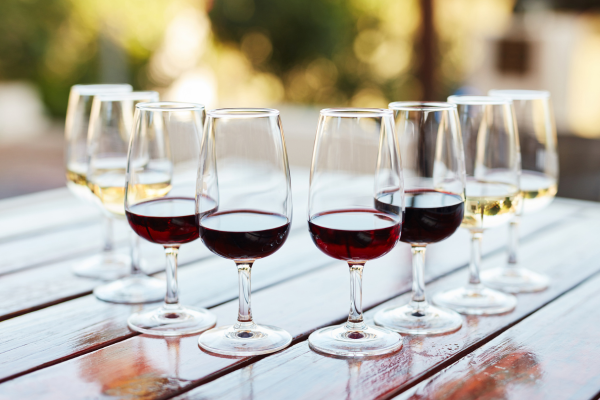 A lineup of wine glasses with different coloured wines in them
