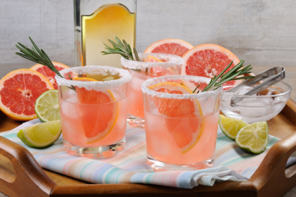 a few glasses of pink paloma on a tray