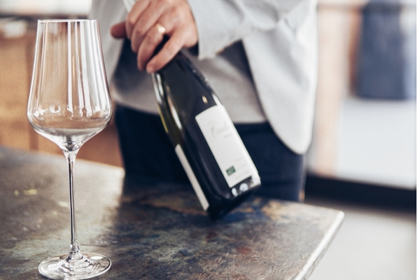 close up of waiter's hands opening a bottle of wine