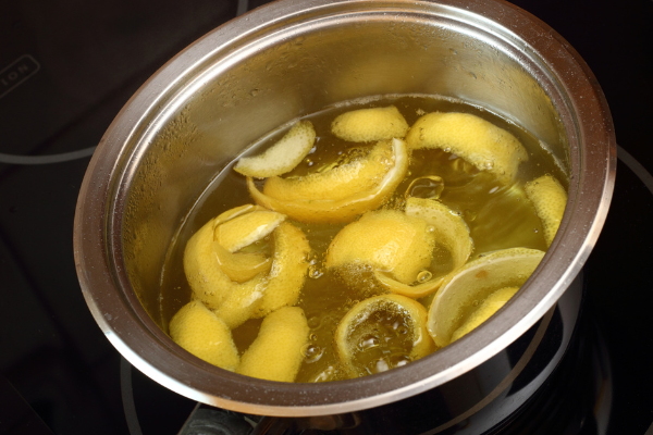 lemon peels in a steel pot of hot syrup