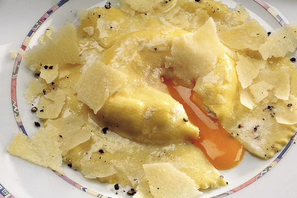 A close up on a raviolo cut open and oozing orange yolk (Image from la cucina italiana)