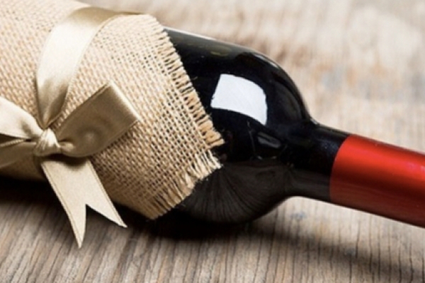 Wine bottle wrapped in twine with a gift tag