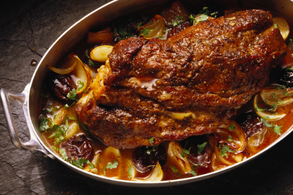overhead shot of pork in a pot with prunes and sauce