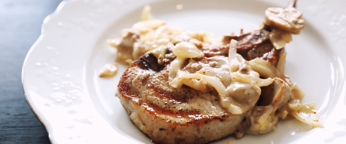 bone in pork chop topped with cream sauce