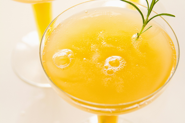 Overhead view yellow-orange cocktail in a coup