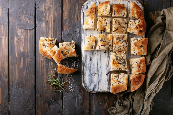 overhead view of focaccia cut in square on a wood board