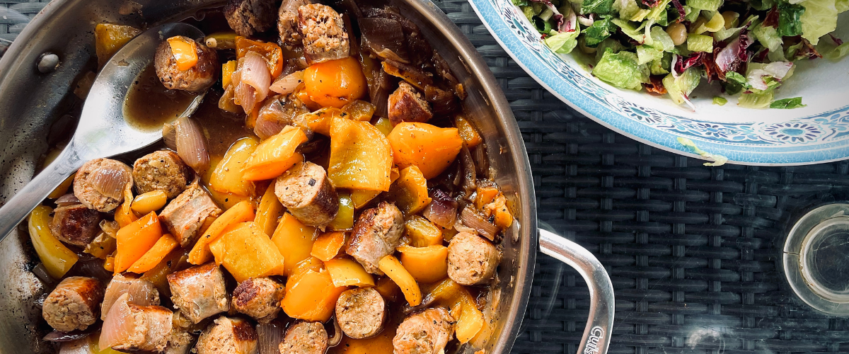 overhead view of sausage and peppers in a pan