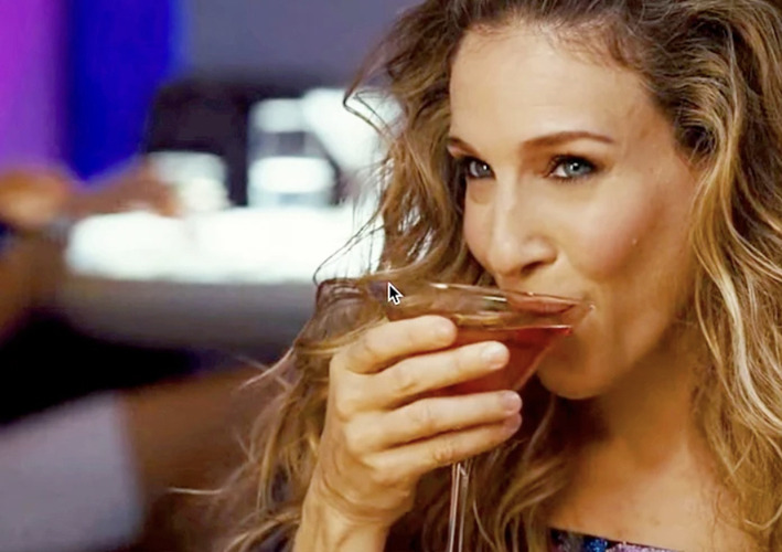 Sarah Jessica Parker, as Carrie Bradshaw, sipping a cosmo in Sex and the City