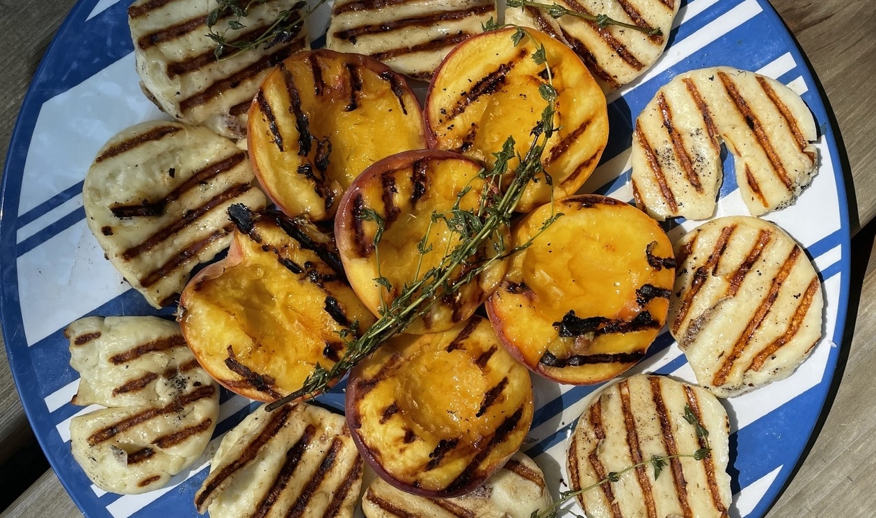 Halloumi and peaches with grill marks on a plate from overhead view