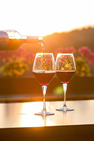 red wine being poured against a sunset