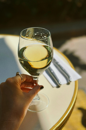 Hand Holding a Glass of White Wine Outdoors