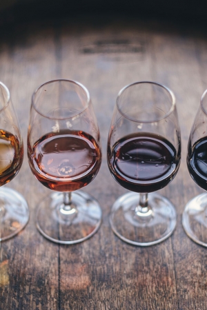 A line up of four glasses of red, white and rosé on a wine barrel