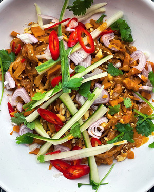 Close up of a white bowl filled with noodles and colourful vegetables